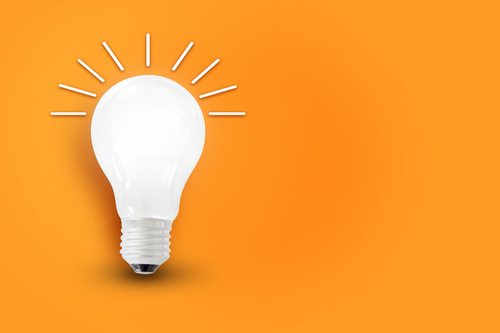 Light bulb and light rays on orange represents nonprofit communications insights